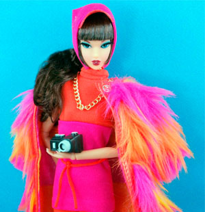 Barbie doll wearing a bright pink and orange coat