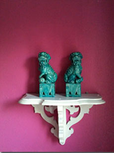 Green Foo Dogs with a bright pink wall in the background