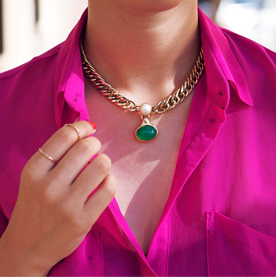 Bright pink blouse with green pendant